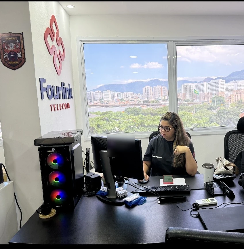 Atendimento ao cliente no escritório da Fourlink, com vista para o Rio de Janeiro