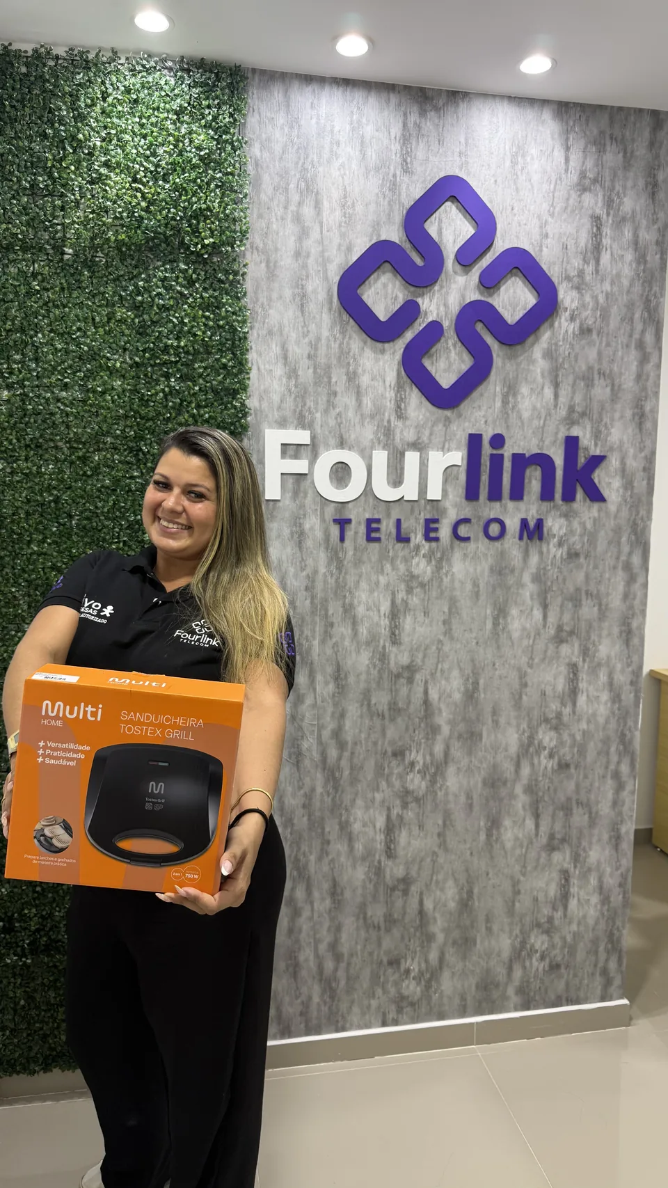 Colaboradora da Fourlink recebendo premiação por desempenho