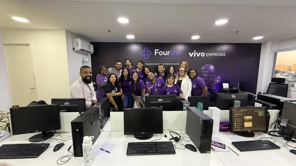 Time da Fourlink diante da parede de parceiro autorizado Vivo Empresas